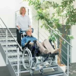 caregiver using a Scalamobil to transport an individual down the stairs