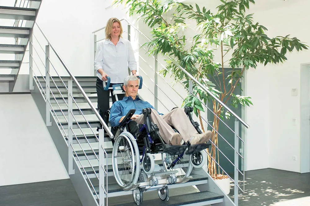 caregiver using a Scalamobil to transport an individual down the stairs