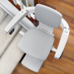 Close-up of the Bruno Elan stair lift's folded seat, armrests, and footrest showing its compact profile
